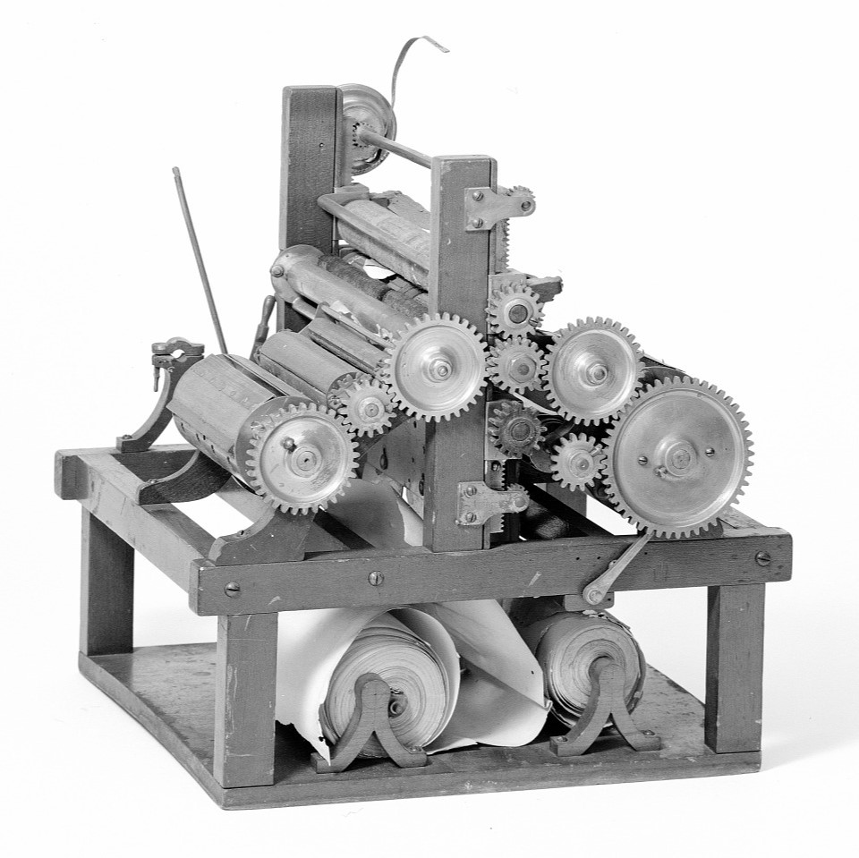 This patent model demonstrates an invention for a compact rotary press with forms for printing both sides of the paper, mounted on the two ends of a single type cylinder.